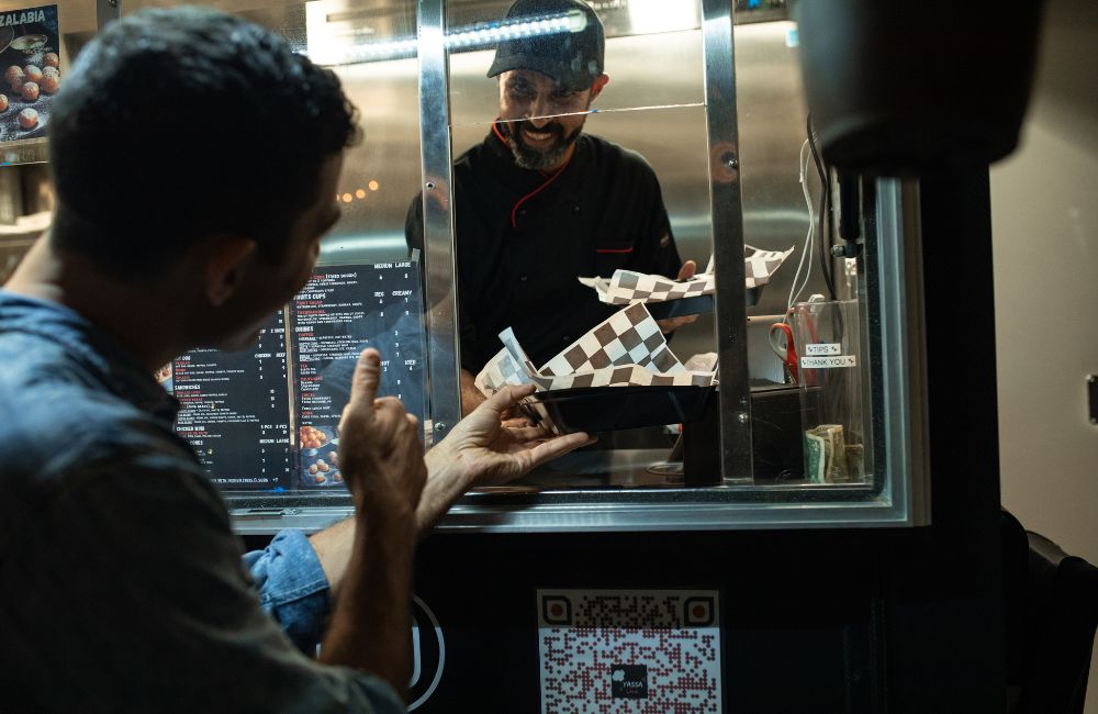 Man serving burger from food truck